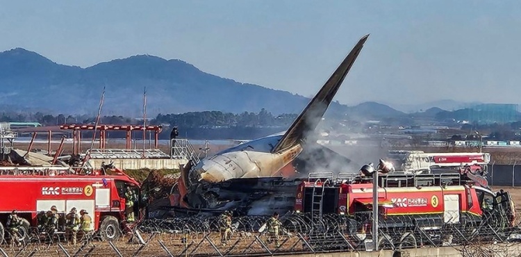 Bombeiros trabalham para apagar incêndio em avião que sofreu acidente na Coreia do Sul — Foto: Yonhap via REUTERS